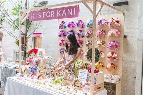 a woman standing in front of a table with lots of flowers and ...