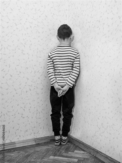 Monochrome of a lonely little boy who is standing corner of the room ...