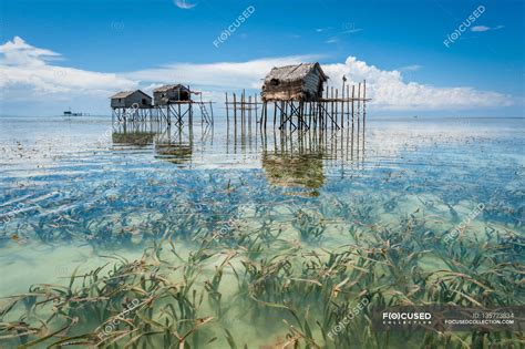 Stilt huts reflected in sea — daytime, stilt house - Stock Photo ...