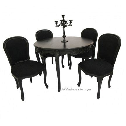a dining table with four chairs and a chandelier on the top of it