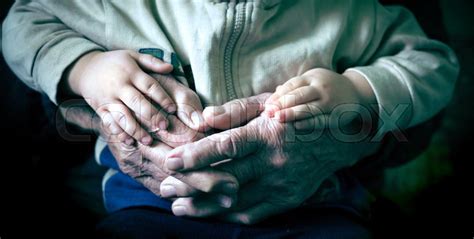 Old hand holding and young holding ... | Stock image | Colourbox