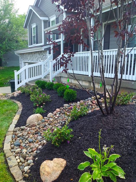 The assorted colors of the riverbed rocks add interest to an otherwise ordinary planting surface ...