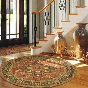 the foyer: door rug, round floor rug, vases beside the stairwell ...