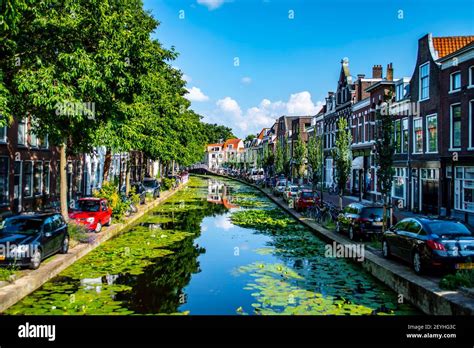 Delft, Netherlands - July 11, 2019: View of canals and brick houses of the town of Delft in the ...