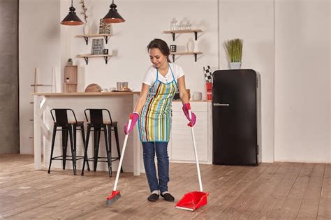 Premium Photo | Young woman sweeping floor on the kitchen