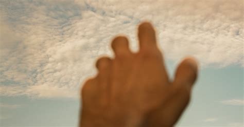 Man Reaching with a Hand to the Cloudy Sky · Free Stock Photo