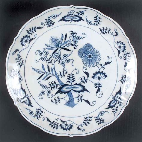 a blue and white plate with floral designs on it's rim, sitting on a black surface