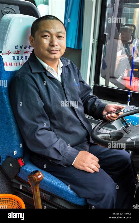 Guilin, China. Bus Driver, with Cell Phone Stock Photo - Alamy