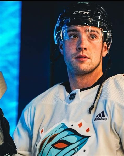 a man wearing a hockey uniform and holding a bat in one hand while ...