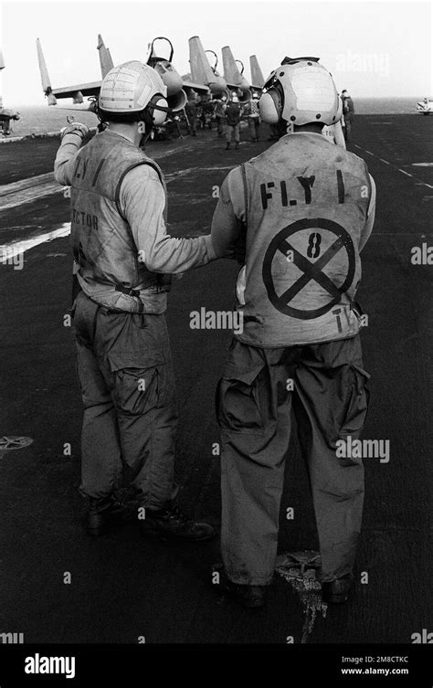 Flight deck crew members stand by aboard the aircraft carrier USS JOHN ...