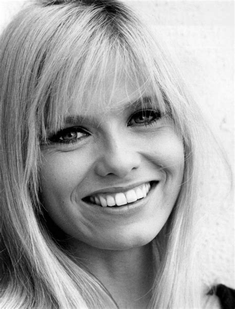 a black and white photo of a woman with long blonde hair smiling at the camera