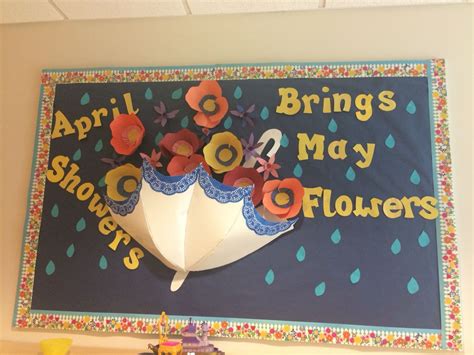 "April showers bring May flowers" spring classroom bulletin board. Paper poppies and daffodils ...