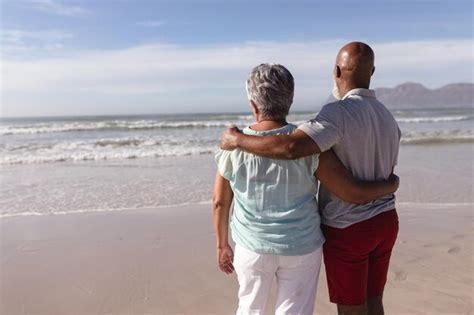 Premium Photo | Rear view of senior african american couple hugging each other on the beach ...