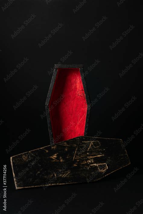 Miniature open black-red coffin on a black background. Festive ...