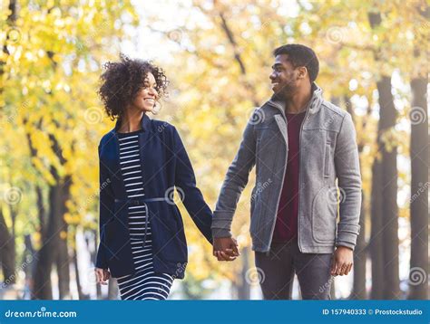 Black Couple Holding Hands while Walking by Autumn Park Stock Image ...