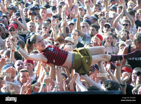 A female concert fan is shown body surfing across the top of the crowd ...