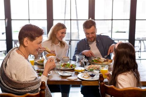 Free Photo | Medium shot family eating together at table