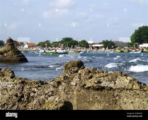 Serang, Indonesia - May 24, 2019: Coral reef with a background of traditional fishing boats on ...