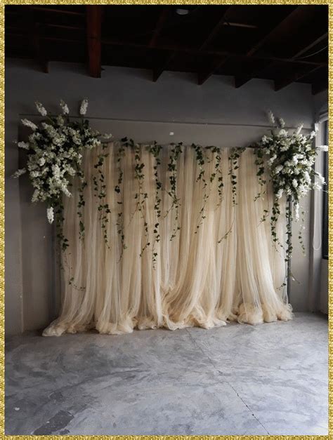 an arrangement of white flowers and greenery decorates the backdrop for a wedding ceremony