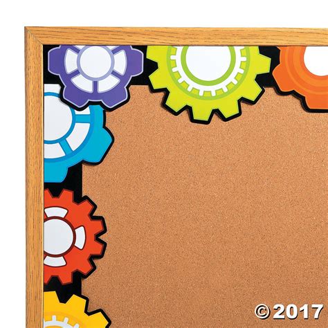 a cork board with gears on it in front of a white background and an orange frame