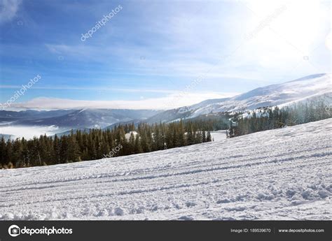 Ski slope at snowy resort Stock Photo by ©belchonock 189539670