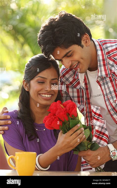 Man giving flowers to a woman Stock Photo - Alamy