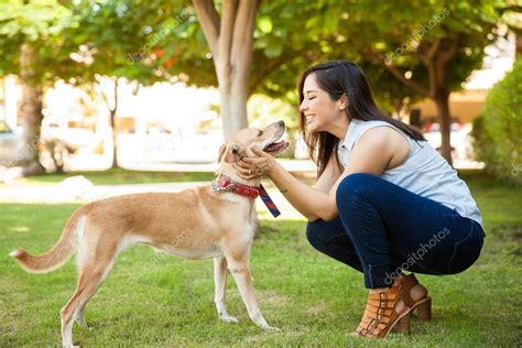 Young woman petting her dog — Stock Photo © tonodiaz #125639966