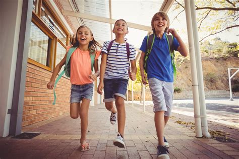 Happy school kids running in corridor at school - The CARE Counseling Center