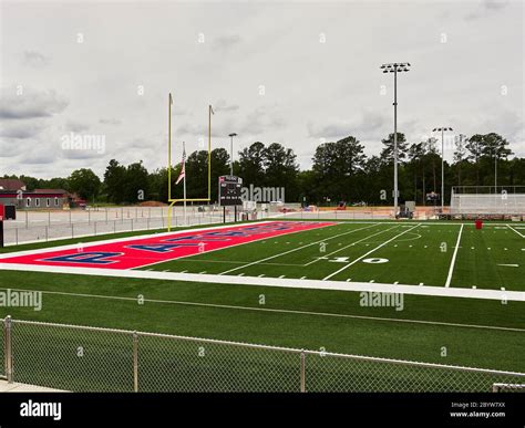 New colorful artificial turf at the end zone and goal post of a high school football field in ...