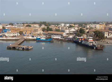 Africa, Gambia. Capital city of Banjul. Overview of port area of Banjul. Over crowded ferry boat ...