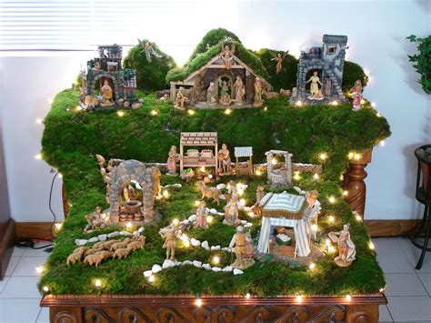 a nativity scene is displayed on top of a table with christmas lights ...
