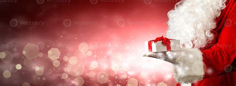 Santa Claus hand holding a wrapped Christmas present. 4957962 Stock Photo at Vecteezy