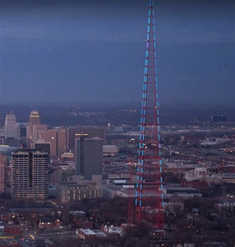 an aerial view of a tall tower in the middle of a city at night time