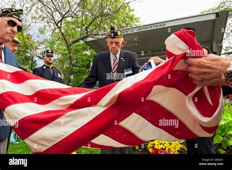 Veterans, members of American Legion Post, folding American flag (close ...