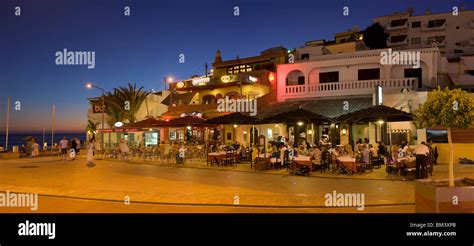 Portugal, The Algarve, Praia Do Carvoeiro, Restaurants At Dusk On The Sea Front Stock Photo - Alamy