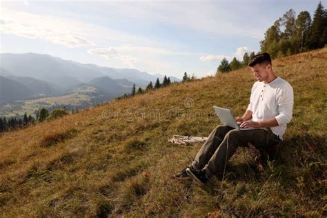 Man Working with Laptop Outdoors Surrounded by Beautiful Nature. Space for Text Stock Image ...