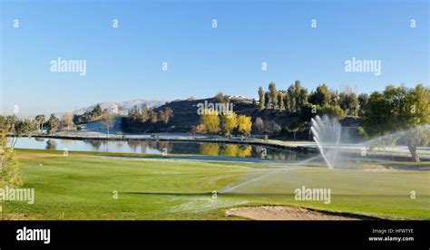 Sprinklers watering on a golf course Stock Photo - Alamy