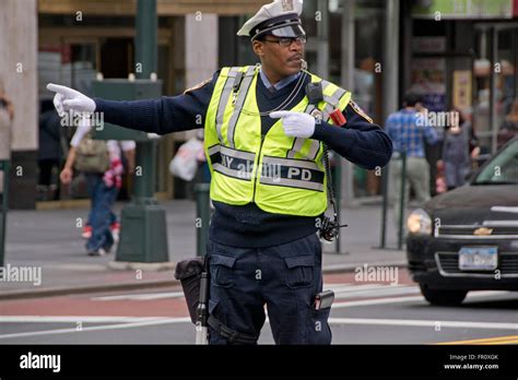 A male New York City Traffic Enforcement Officer directing cars at East 34th Street and Park ...