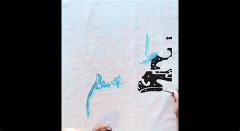 someone is drawing on the side of a wall with blue spray paint and black ink