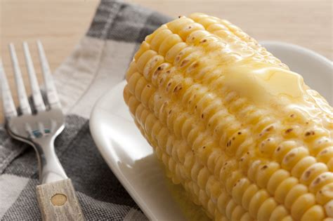 Close-up of cooked corn-cob with butter on top - Free Stock Image