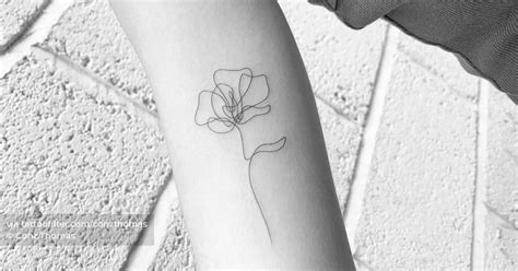 One line flower tattoo on the inner arm.