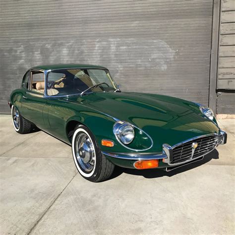 a green car parked in front of a garage door