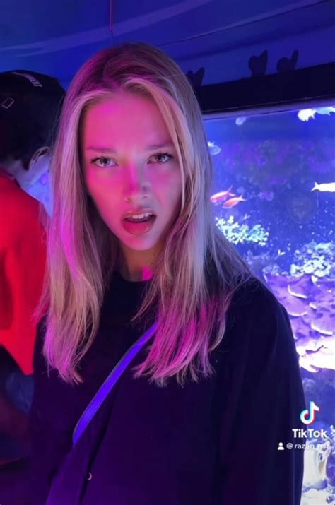 a woman standing in front of an aquarium