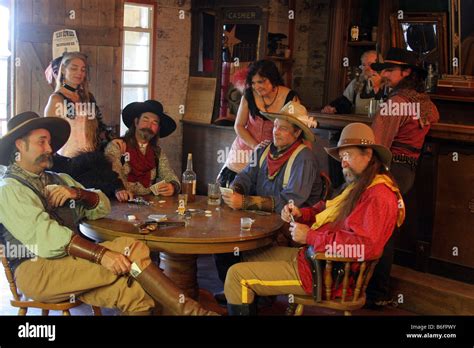 A cowboy pulling an ace from his boot while playing Poker in an old ...