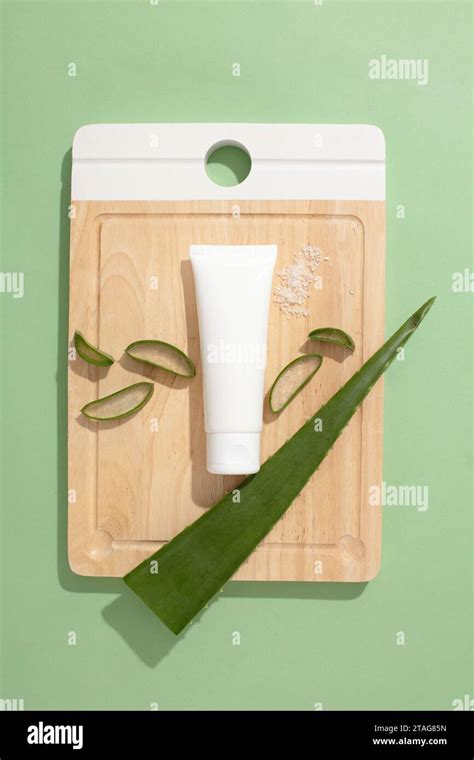 Top view of an empty plastic tube and fresh aloe vera leaves displayed ...