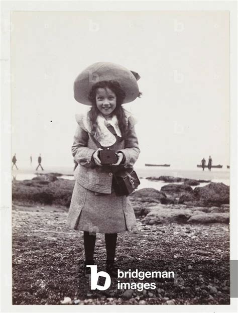 'Kodak Brownie girl on beach holding a Kodak Brownie camera', vers 1900 by