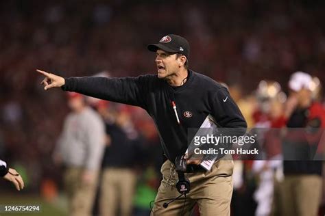 San Francisco 49ers head coach Jim Harbaugh stands on the field... News ...