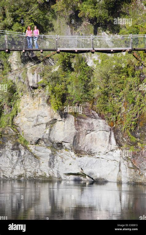 Two girls standing on swing bridge Hokitika Gorge, West Coast, South ...