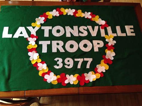 DIY Girl Scout troop banner with bamboo pole and flower lei crest