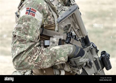 Soldier with assault rifle and flag of Norway on military uniform ...